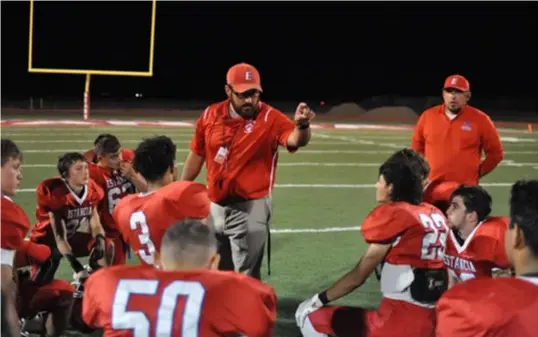  ?? ?? Estancia football’s head coach Stewart Burnett during the postgame huddle after the Bears' loss to Socorro, Sept. 17, 2021. Photo by Ger Demarest.