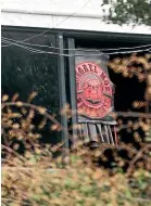  ?? PHOTO: FILE ?? Mongrel Mob insignia hangs from a window the Lawry St property, which was searched by police in August this year.