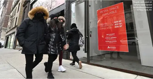  ??  ?? People walk past an
empty retail space on Madison Avenue
in New York, NY.