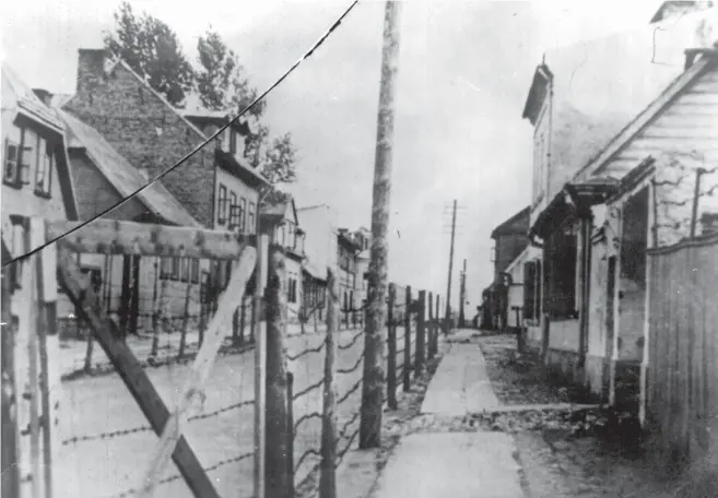  ?? (Yad Vashem Photo Archives) ?? A BARBED-wire fence along Panrow Street, separating the two parts of the Kovno ghetto in Lithuania.