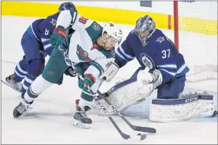  ?? CANADIAN PRESS PHOTO/JOHN WOODS ?? Minnesota Wild’s Jordan Greenway (18) can’t get the puck past Winnipeg Jets goaltender Connor Hellebuyck (37) during Game 5 of their first-round NHL playoff series in Winnipeg on Friday. The Jets advanced with a win in the game as Hellebuyck posted his...