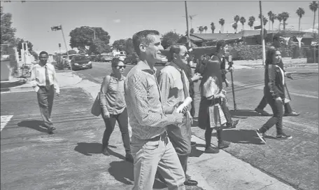  ?? Photog r aphs by Gina Ferazzi Los Angeles Times ?? MAYOR Eric Garcetti walks along Concord Street to ask residents to have their soil tested for toxins emitted by Exide Technologi­es.