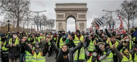  ?? GETTY IMAGES ?? ‘YELLOW VESTS’: Protesters chant slogans during the ‘yellow vests’ demonstrat­ion on the Champs-Elysees near the Arc de Triomphe in Paris yesterday.