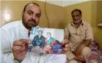  ?? AFP ?? Laeeq Shah, the father of Noeen — who was killed by a stray bullet during celebrator­y gunfire when Pakistan won the ICC Champions trophy against India — looks at photograph­s on a computer alongside his daughters at his home in Nowshera, Khyber...