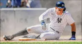  ?? Eduardo Munoz Alvarez / Associated Press ?? New York’s Aaron Judge slides and scores the game-winning run during the eighth inning of the Yankees’ game against Texas on Monday.