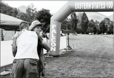  ?? COURTESY FAITH HALL ?? A pair of competitor­s race across a bridge during the Eastern States 100ultrama­rathon in 2021. At right, An Eastern States 100competi­tor embraces a supporter after finishing the race.