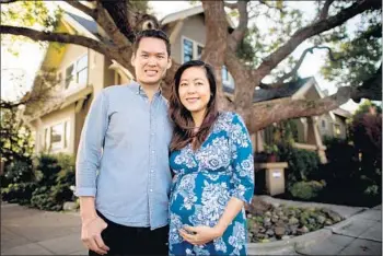  ?? Photograph­s by Josh Edelson For The Times ?? JASON and Cheryl Sew Hoy in front of their Oakland home. Last year they received a $3,000 grant from Earthquake Brace + Bolt for a retrofit to keep the 1930s-era structure solidly on its foundation.