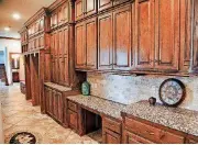  ??  ?? Above: A long hallway just off the kitchen is lined with cabinets and space for a second refrigerat­or at 12916 Endor Court. Below: The master closet with dressing area.