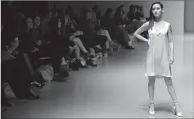  ?? NWA Democrat-Gazette/ANDY SHUPE ?? A model walks the runway Thursday during NWA Fashion Week at Drake Field in Fayettevil­le. Sara Soo McGuigan won the Emerging Designer Award for this dress.