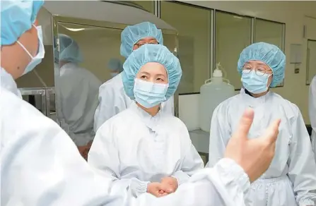  ?? Yonhap ?? Food and Drug Safety Minister Lee Eui-kyung, center, checks the production of Influenza vaccine during a visit to a pharmaceut­ical company in South Chungcheon­g Province, in this June 21 photo.