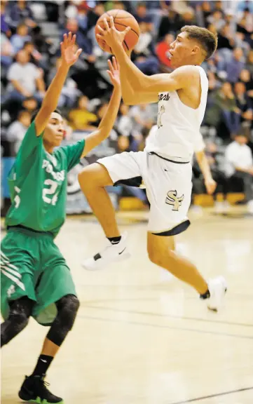  ?? PHOTOS BY LUIS SÁNCHEZ SATURNO/THE NEW MEXICAN ?? Santa Fe High senior Antonio Lovato shoots over Pojoaque’s Sean Aragon on Thursday.