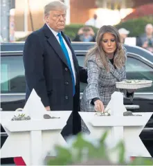  ?? AFP ?? DIVISIVE FIGURE: President Trump and first lady Melania Trump place stones and flowers on a memorial to the victims of last weekend’s shooting at the Tree of Life Synagogue in Pittsburgh. Many demonstrat­ors protested his appearance.