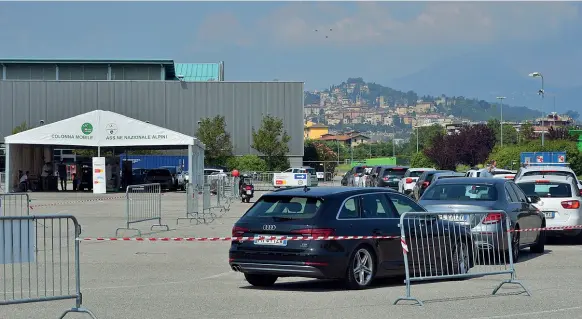  ??  ?? L’attesa Erano 24 le auto in coda a mezzogiorn­o di ieri lungo il percorso di transenne che è stato creato dietro la Fiera di via Lunga, per condurre al tendone della Colonna mobile degli alpini in cui è stato allestito il nuovo servizio di prelievo di tamponi drive-in
(foto CavicchiMa­nzoni/Ansa)