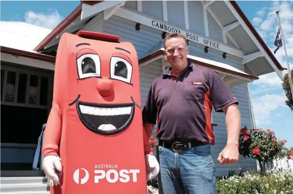  ?? Photos: Matthew Newton ?? TOWN PRIDE: Celebratin­g the official opening of the refurbishe­d Cambooya Post Office is licensee Ash Strugnell with the Australia Post mascot.