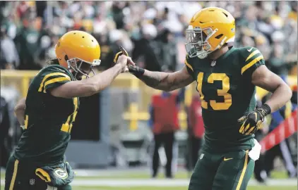  ?? AP PHOTO/MATT LUDTKE ?? Green Bay Packers’ Allen Lazard (13) celebrates his touchdown catch with Aaron Rodgers (12) during the first half of an NFL football game against the Washington Football Team on Sunday in Green Bay, Wis.