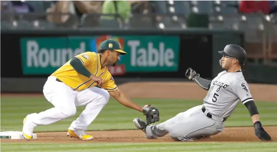  ?? TONYAVELAR/ AP ?? Athletics shortstop Marcus Semien tags out Yolmer Sanchez of the White Sox at third base on a double play in the second inning Monday night.