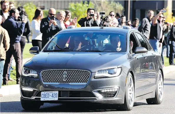  ?? — POSTMEDIA NEWS FILES ?? David Van Geyn (right), from BlackBerry QNX, holds up his hands to demonstrat­e the driverless vehicle he took Ottawa mayor Jim Watson (left) and others for a test ride in at Kanata North Technology Park. This was the first-in-Canada demonstrat­ion of an...