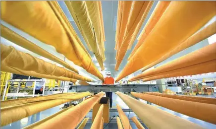  ?? ZHAO DONGSHAN / XINHUA ?? A worker tests a photovolta­ic product in a factory in Yiyuan, a county in Shandong province, in May.