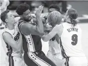  ?? CHRIS SZAGOLA AP ?? The 76ers’ Joel Embiid, is defended by the Heat’s Duncan Robinson, left, Chris Silva and Kelly Olynyk.