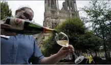  ?? FRANCOIS MORI — THE ASSOCIATED PRESS ?? A waitress serves a glass of champagne at La Grande Georgette restaurant in front of the cathedral in Reims, the Champagne region, east of Paris.