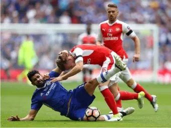  ??  ?? Costa tussles with Rob Holding at Wembley