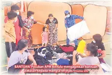  ?? — Gambar APM ?? BANTUAN: Pasukan APM Bintulu mengagihka­n bantuan
pakaian kepada mangsa terjejas.