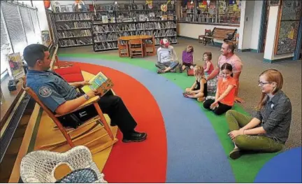  ?? SCOTT ROMAN — DIGITAL FIRST MEDIA FILE PHOTO ?? Telford police Sgt. Dave Bechtel reads to participan­ts of a reading program at the Indian Valley Library in this 2014 file photo.