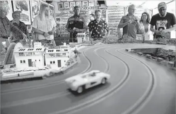  ?? Photograph­s by Marcus Yam Los Angeles Times ?? MEMBERS of the private FarrOut Slot Car Club, the brainchild of lifelong racer Stephen Farr-Jones, gather at his house in Glendale. “All my friends come over, and we drink and drive,” Farr-Jones said.