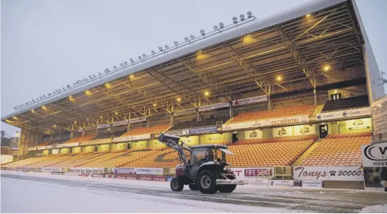  ??  ?? 0 A tractor shifts snow from the Tannadice pitch but Dundee United’s game against Queen of the South on Tuesday was postponed due to the weather.