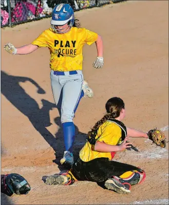  ?? SARAH GORDON/THE DAY ?? Waterford’s Madison Nott scores following an inside-the-park home run in the fifth inning Monday, as Stonington catcher Erin Craig tries to apply the tag. Nott’s home run tied the game 5-5 before Stonington won it 6-5 in the bottom of the eighth on a...