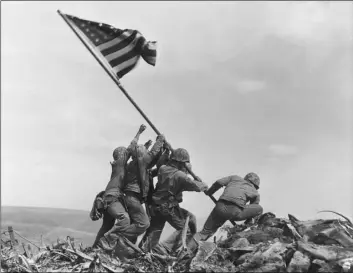  ?? AP Photo/Joe Rosenthal ?? In this 1945 file photo, U.S. Marines of the 28th Regiment, 5th Division, raise an American flag atop Mt. Suribachi, Iwo Jima, Japan.