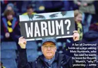  ??  ?? A fan of Dortmund holds up a sign asking Mats Hummels, who has said he wants to leave for Bayern Munich, “why?” yesterday. –