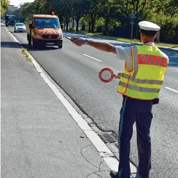  ?? Foto: Thomas Heckmann ?? Ein Polizist mit Warnweste und Kelle hält all die Fahrer an, die ein sogenannte­r Späher vorher mit dem Handy am Steuer oder bei anderen Verstößen beobachtet hat.