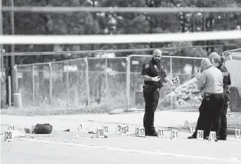  ?? Photos by Karen Warren / Staff photograph­er ?? Harris County sheriff ’s officials investigat­e the scene Wednesday after a man allegedly wielding a knife was shot by a deputy near a convenienc­e store in the 12900 block of Telge in Cypress.