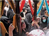  ?? K.M. CHAUDARY/AP ?? Shiite women surround a religious float during a Muharram procession in Lahore, Pakistan. Muharram, the first month of the Islamic calendar, is a month of mourning for Shiites marking the death of Hussein, the grandson of the Prophet Muhammad, at the Battle of Karbala in present-day Iraq in the 7th century.