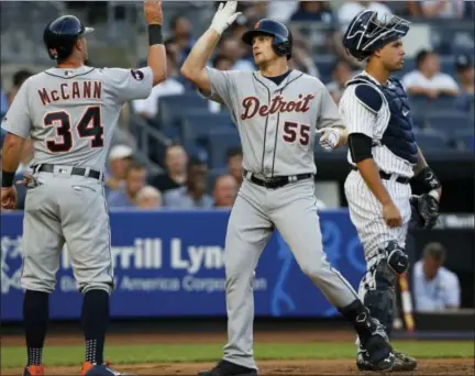  ?? KATHY WILLENS — THE ASSOCIATED PRESS ?? The Tigers’ James McCann (34) greets John Hicks at the plate after Hicks’ three-run home run in the second inning on Tuesday.