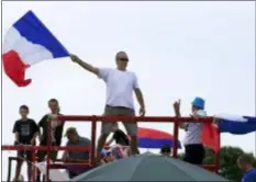  ?? PETER DEJONG — THE ASSOCIATED PRESS ?? Spectators wave the French flag as they wait for the pack to pass during the fourth stage of the Tour de France cycling race over 121 miles with start in La Baule and finish in Sarzeau, France, Tuesday, July 10, 2018.