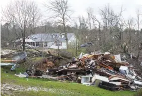  ?? AP PHOTO/VASHA HUNT ?? Debris litters weather-damaged properties at the intersecti­on of County Road 24 and 37 in Clanton, Ala., the morning following a large outbreak of severe storms across the southeast Thursday.