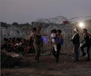  ?? ERIC GAY, FILE — THE ASSOCIATED PRESS ?? Migrants who crossed the Rio Grande and entered the U.S. from Mexico are lined up for processing by U.S. Customs and Border Protection on Sept. 23in Eagle Pass, Texas.