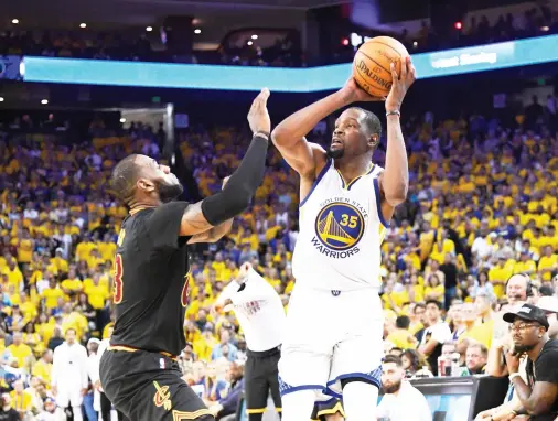  ??  ?? Golden State Warriors forward Kevin Durant shoots over Cleveland Cavaliers forward LeBron James during the second half in Game 2 of the 2017 NBA Finals at Oracle Arena on Sunday. (USA TODAY Sports)