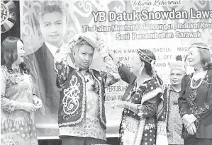  ?? ?? NGETANKA MAIN ASAL: Snowdan lebuh ti dibantu Hau (tiga kanan) maya ngena ngepan tradisiona­l enggau kereban selapuk Orang Ulu maya pengerami Malam Penyerakup Etnik Orang Ulu Sarawak di Kuching, kena malam Hari Enam.