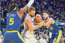  ?? Jeff Chiu/Associated Press ?? Sacramento forward Domantas Sabonis is sandwiched between the Warriors’ Kevon Looney and Klay Thompson.