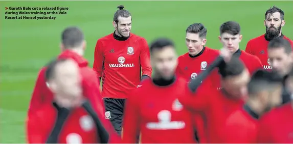  ??  ?? > Gareth Bale cut a relaxed figure during Wales training at the Vale Resort at Hensol yesterday