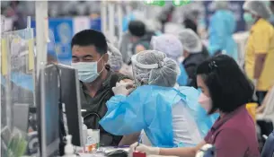 ?? APICHART JINAKUL ?? Medical personnel administer Covid-19 vaccines at a vaccinatio­n centre at Bang Sue Grand Station. The central bank forecasts the Thai economy would recover to pre-pandemic levels by early 2023 under its baseline scenario.