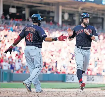  ?? [GARY LANDERS/THE ASSOCIATED PRESS] ?? Carlos Santana, left, and Jason Kipnis of the Indians slap hands after both scored on a ninth-inning single by Jake Bauers to break open the game against the Reds.