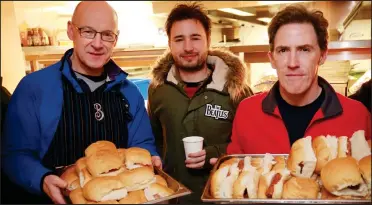  ??  ?? Deputy First Minister John Swinney, Josh Littlejohn and Rob Brydon hand out bacon rolls after the Sleep in the Park