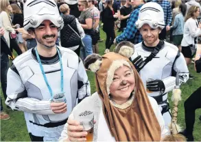  ??  ?? Ice planet hops . . . Star Warsthemed beer enthusiast­s Mark Robinson (left), Sarah Moulton and Luke Haslemore escape the cold and grab some ales at the festival.