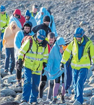  ?? Picture: SPLASH NEWS ?? JOURNEY’S END: Migrants escorted from a beach near Folkestone last month