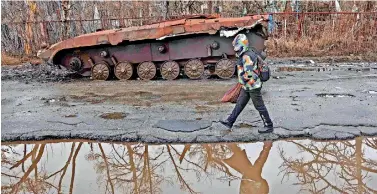  ?? ?? A woman walk past a destroyed armoured military vehicle in the Svyatogirs­k town, Donetsk region. (Photo by Anatolii STEPANOV / AFP)