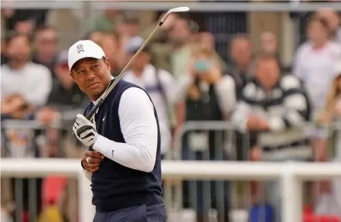  ?? GERALD HERBERT/ASSOCIATED PRESS ?? Tiger Woods reacts to dust after playing a shot Thursday on the first hole during the British Open on the Old Course at St. Andrews, Scotland. Woods ended the day with 78, his second-worst score in his Open career.